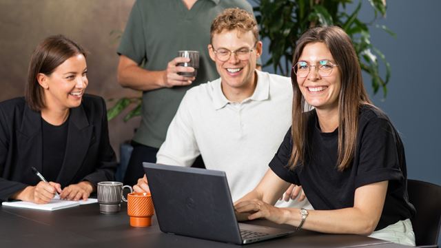 Tre kollegorsom tillsammans tittar på en dator